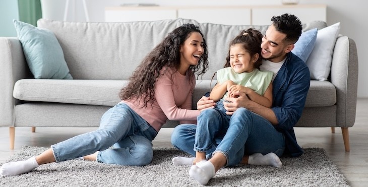 Middle Eastern Parents Having Fun With Their Little Daughter At Home, Arabic Mom And Dad Tickling Female Kid And Laughing Together In Living Room, Enjoying Domestic Leisure, Copy Space